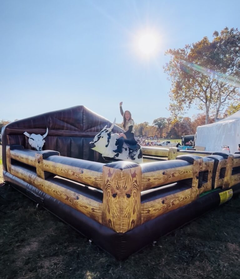 Girl Riding mechanical bull at a horse race