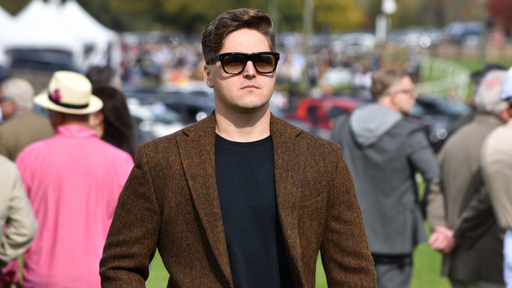 Man wearing a brown tweed blazer and sunglasses at the Far Hills Race Meeting, showcasing classic men’s fall race day style.
