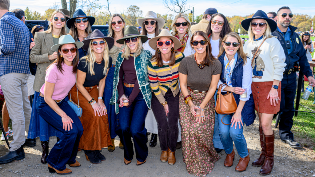 Group of women wearing hats, boots, sweaters and colorful fall race day fashion at the Far Hills Race Meeting.