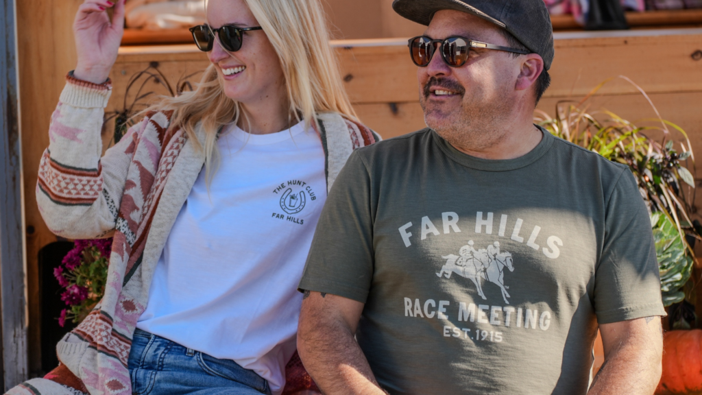 Far Hills Race Meeting guests wearing branded Hunt Club and Far Hills apparel with casual fall layers on race day.