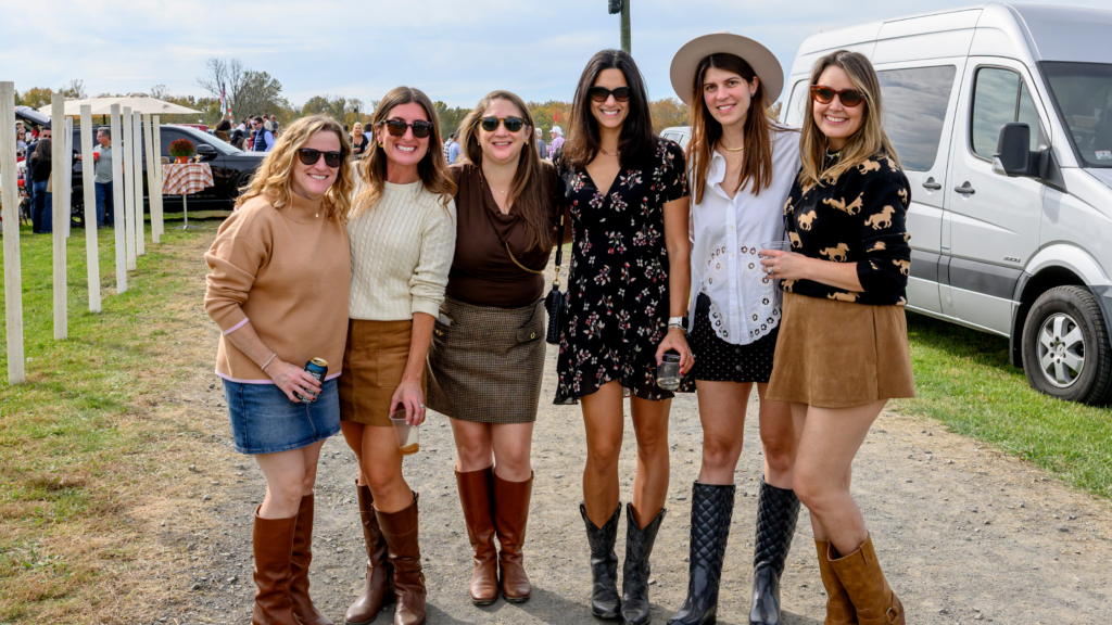 Group of women in fall race day outfits, boots and neutral layers at the Far Hills Race Meeting in New Jersey.